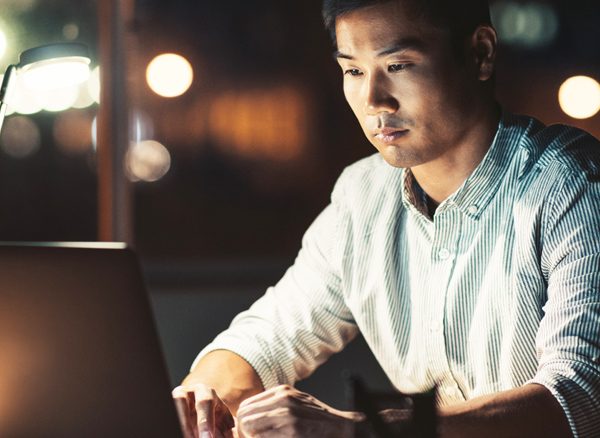 Man using CTM shift management tools on his laptop in the evening