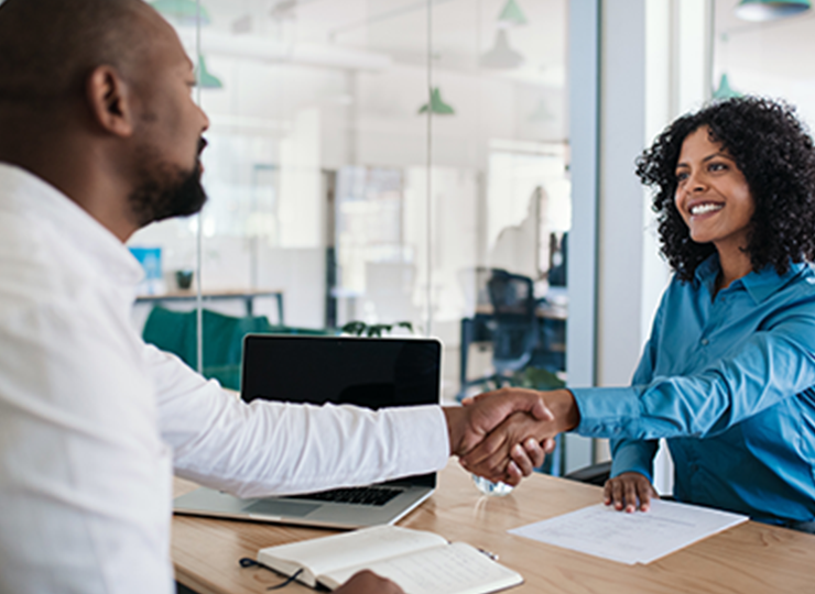 Two colleagues shaking hands in office